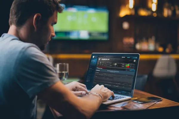 Uma mulher sorrindo enquanto joga online em seu laptop, cercada por elementos de cassino em néon, destacando a coleção diversificada de jogos do QWE123.